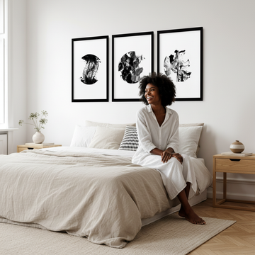 Black woman with minimalistic wall art in a bright Scandinavian rental bedroom — how to choose wall art for rental spaces