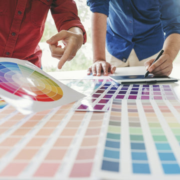 Two designers pointing at colour swatches and charts, exploring colour psychology in interior design
