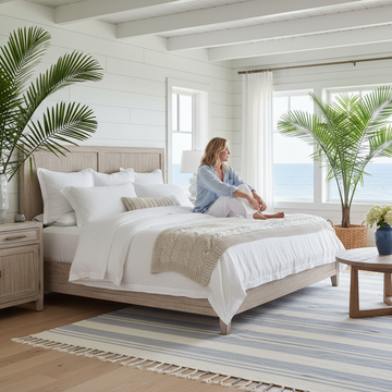 Bright airy coastal master bedroom with white walls and soft blue accents