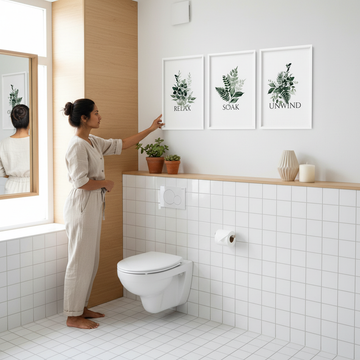 Bright minimalistic bathroom with above toilet decor featuring floating shelves, plants, and framed wall art