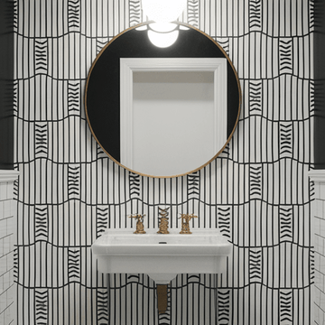 A striking way to decorate a powder room with bold black and white geometric wallpaper and brass fixtures