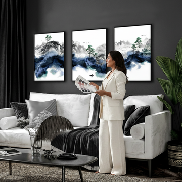 Stylish woman holding paint colour swatch against a dark grey wall with Japanese wall art prints, showing how to match wall art to paint colours
