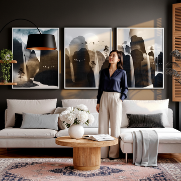 Stylish woman in a beautifully refreshed living room with contemporary wall art prints, sage sofa and fresh flowers, showing how to refresh a living room on a budget