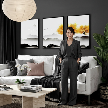 Stylish woman in a dramatic Feng Shui living room with Japanese decor art prints on a deep navy wall, paper lantern light and bamboo plant, showing how to incorporate Feng Shui home design