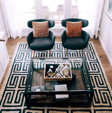 Modern scandi style home decor living room with two dark armchairs and geometric patterned rug