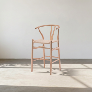 1. Wishbone natural wood bar stool in sunlight