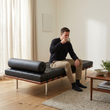 10. Barcelona black leather daybed with a person seated and enjoying coffee
