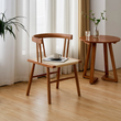 13. Eenoch natural wood dining chair beside a round table