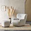 2. Carmen armchair and footstool beside a decorative vase