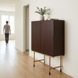 2. Delta walnut drinks cabinet in an ivory hallway with a person in the background