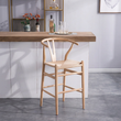 2. Wishbone natural wood bar stool beside a home bar
