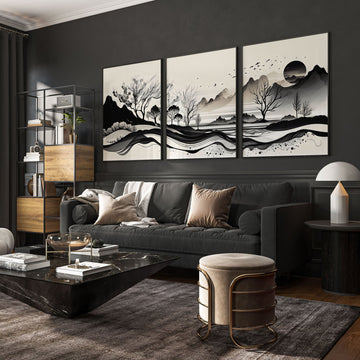 3 large pictures on wall above a grey sofa in a sophisticated dark living room