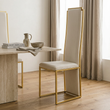 4. Deana gold frame dining chair viewed at an angle beside a stone table