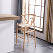 4. Wishbone natural wood bar stool beside a window