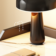 Table lamp on a desk with a notebook and pen, warm lighting