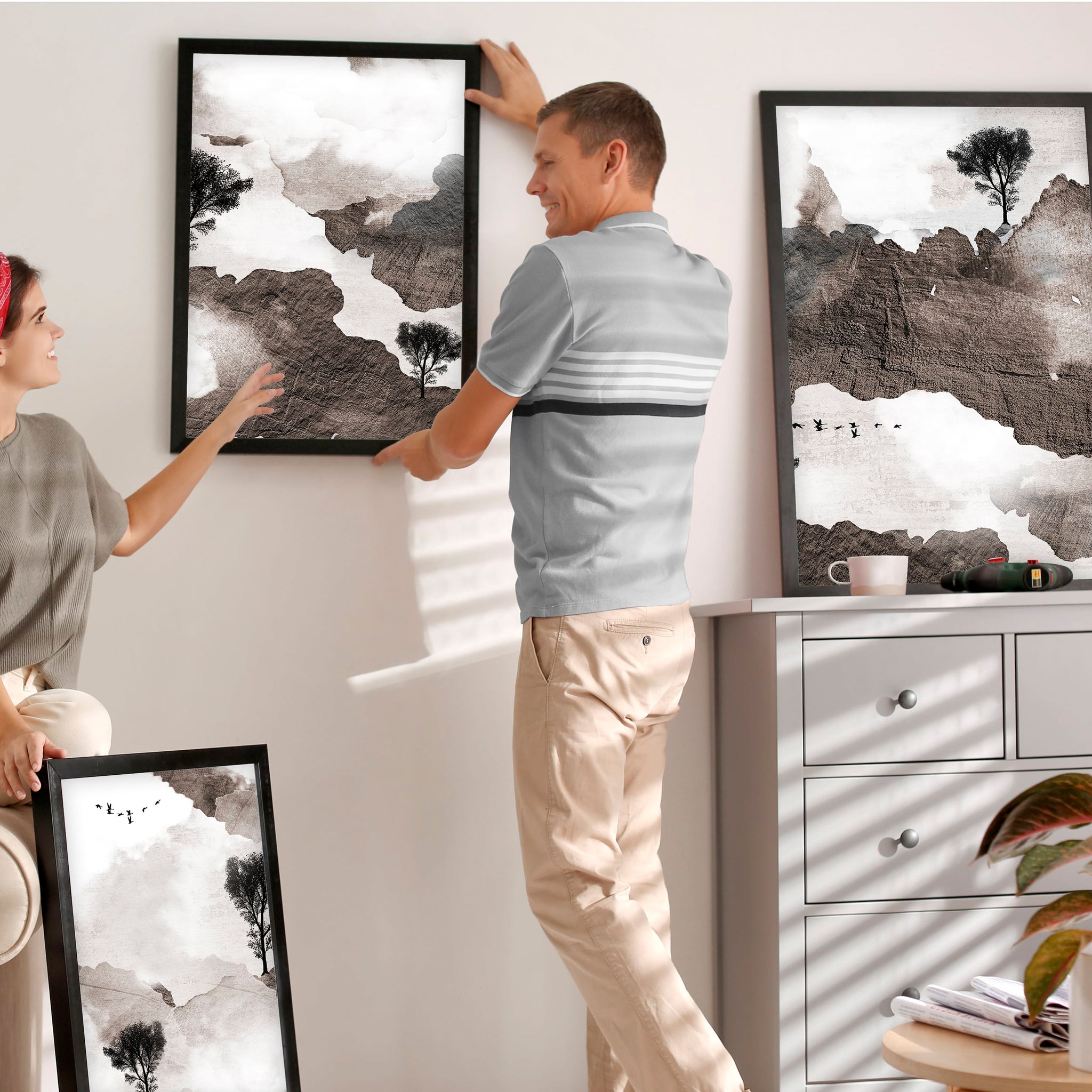 A couple is embellishing their calm living room with Earth tone unique wall art prints.