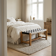Satna black and white jute woven bench at the foot of a bed in a wide bedroom view