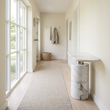 Sesto white marble console table in a wide Scandinavian hallway view