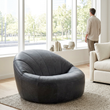 Hoxton antique black leather cocoon chair in a bright living room with a person in the background
