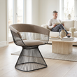 Vogue mink velvet chair viewed at an angle in a bright living room with a person in the background