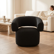Oliveto black boucle swivel armchair in a bright living room with a person in the background