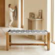 Satna black and white jute woven bench in a bright hallway with a person in the background