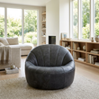 Hoxton antique black leather cocoon chair in a wide Scandinavian living room view