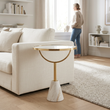 Oria white glass round side table with marble base in a bright living room with a person in the background
